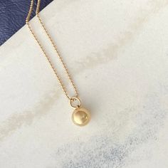 Made of solid 14k gold, our sphere charm symbolizes completeness and connection for those who wear it. It embodies the essence of our Golden Geometry collection, showcasing the beauty of form, the precision of mathematics, and the timeless allure of nature's perfect shapes. the Sphere pendant is available in solid 14k gold + sterling silver all charms come on a 14k gold ball chain necklace pendants are first hand carved in wax and then cast in either 14k gold or sterling silver perfect for every Classic 14k Gold Ball Chain Necklaces, 14k Gold Necklace With Ball Chain, Yellow Gold Pendant Charm Necklace With Satellite Chain, Sterling Silver Pendant Necklace With Ball Chain, Yellow Gold Necklace With Satellite Chain, 14k Yellow Gold Satellite Chain Charm Necklace, 14k Yellow Gold Charm Necklace With Satellite Chain, Elegant Ball Chain Jewelry, Minimalist Jewelry With Round Pendant Ball Chain