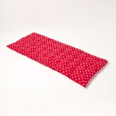 a red and white polka doted sleeping bag on a white surface with the lid open