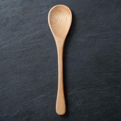 a wooden spoon sitting on top of a black surface