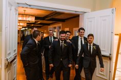 a group of men standing next to each other in front of an open white door