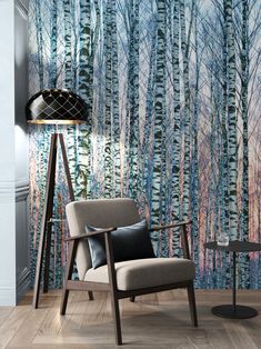 a chair and table in front of a wall with trees painted on the wall behind it