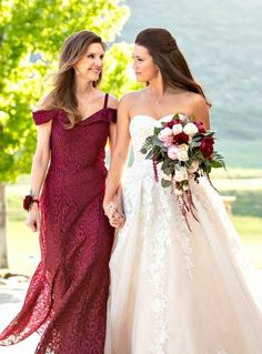 two women in long dresses holding hands