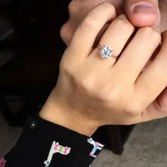 a close up of a person wearing a ring with a diamond on it's finger