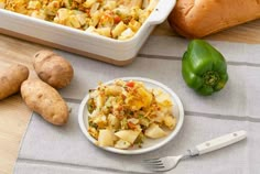 potatoes, green peppers and other vegetables on a table next to a casserole dish