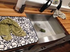 a kitchen sink with a cloth on top of it next to an oven mitt