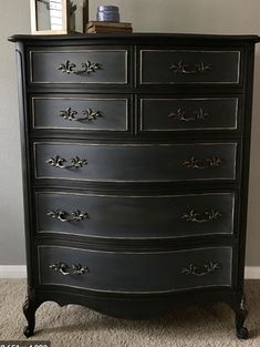 an old dresser is painted black and has gold trimmings on the bottom drawer