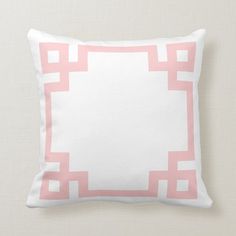 a pink and white pillow with a square design on the front, along with a plain background