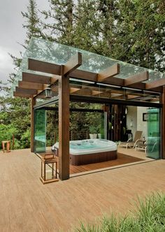 a hot tub sitting on top of a wooden deck next to a lush green forest