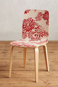 a red and white chair sitting on top of a wooden floor