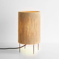 a lamp that is sitting on top of a table next to a white wall and floor