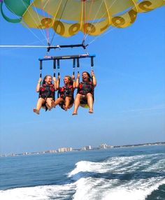 three people are parasailing in the ocean