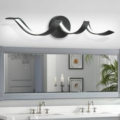 a bathroom vanity with two sinks and a large mirror above it, in front of a white wall