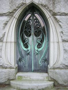 an ornate door is shown on the side of a stone building with steps leading up to it