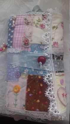 several different pieces of fabric and lace on a white cloth with flowers, hearts, and buttons