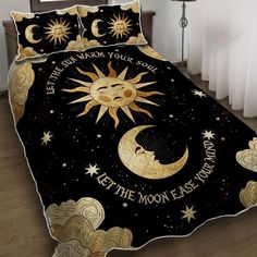 a bed covered in a black and gold comforter with the moon and stars on it