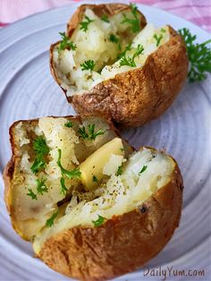 two baked potatoes on a plate with parsley