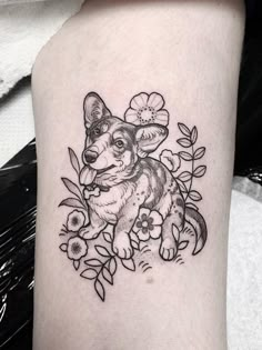 a small dog with flowers on it's leg is shown in black and white