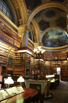 the interior of an old library with many bookshelves and paintings on the ceiling