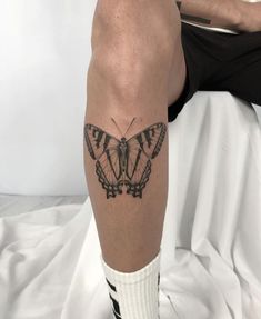 a man with a butterfly tattoo on his leg