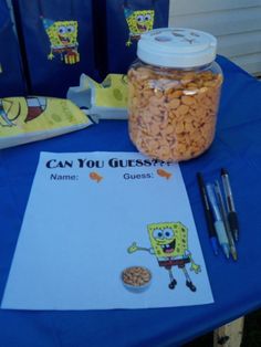 a table topped with a jar filled with cereal next to a notepad and pen