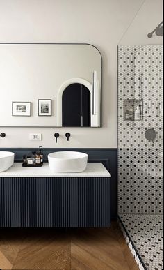 a bathroom with two sinks and a large mirror on the wall next to each other