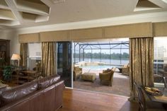 a living room filled with furniture and a fire place next to a window covered in curtains