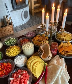 a table filled with different types of food and candles on top of each plate,