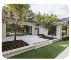 a white house with grass and trees in front