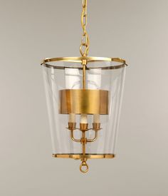 a gold chandelier hanging from the ceiling with clear glass and metal fixtures on it