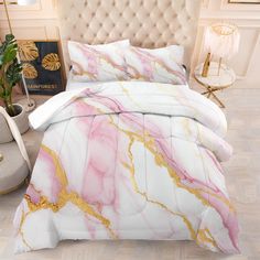 a white bed with pink and gold marbled comforter set on top of it