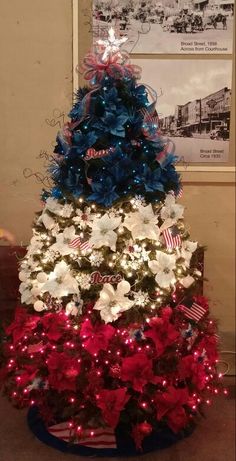 a christmas tree decorated with red, white and blue poinsettis