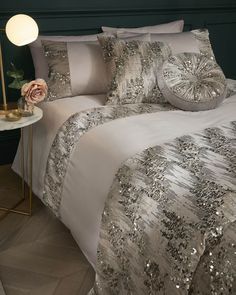 a bed with sequins on it in a room next to a night stand