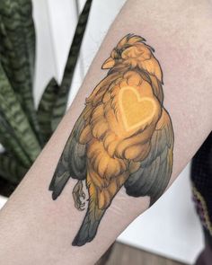 a bird with a heart tattoo on its arm