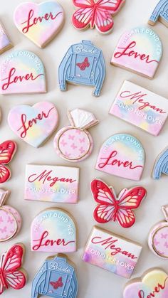 decorated cookies are arranged on a white surface with the word love spelled in red, blue and pink