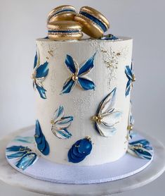 a white cake with blue and gold decorations on it's side, sitting on a platter