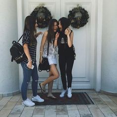 three young women standing in front of a door