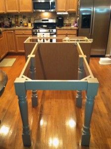 a kitchen with an island made out of plywood and metal pipes in the middle