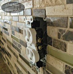 there is a light switch on the wall in this house that has been decorated with stone tiles