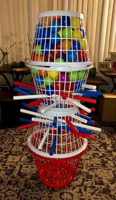 a birdcage filled with lots of different types of balls and sticks in it