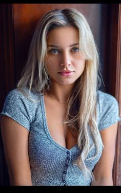 a woman with long blonde hair is posing for the camera