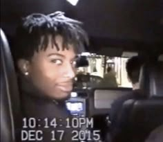 a young man sitting in the back seat of a car