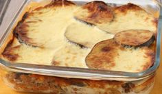 a casserole dish with cheese and meat in it on a yellow napkin next to a striped cloth