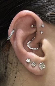 a woman wearing ear piercings with clear stones