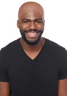 a man with a bald head wearing a v - neck t - shirt and smiling