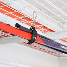 a pair of skis hanging from a rack in a building with orange and white walls