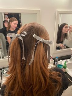 a woman is getting her hair done in the mirror