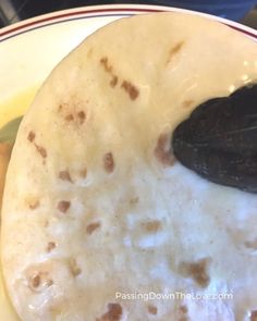 a tortilla on a plate with a black spoon