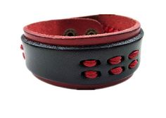 two red and black leather bracelets with buttons on each one side, sitting next to each other