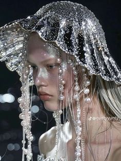 a woman with long hair wearing a hat covered in beads