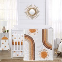 a baby crib bedding set with an orange and brown sun design on it